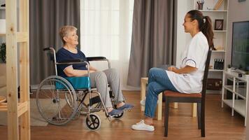 senior kvinna i rullstol har en konversation med sjuksköterska. gammal person pensionering Hem, sjukvård amning, hälsa Stöd, social bistånd, läkare och Hem service foto