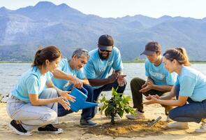 team av ung och mångfald volontär- arbetstagare grupp njut av välgörenhet social arbete utomhus- i träd skog plantering ngo arbete för stridande klimat förändra och global uppvärmningen i kustlinje livsmiljö projekt foto