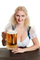 skön ung blond flicka i traditionell kostym drycker ut av oktoberfest öl ölkrus. foto