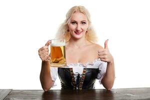 skön ung blond flicka i traditionell kostym drycker ut av oktoberfest öl ölkrus. foto