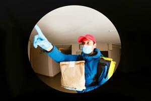 leverans man skicka mat väska på dörr knopp för kontaktlös eller Kontakt fri från leverans ryttare i främre hus för social avstånds för infektion risk. foto