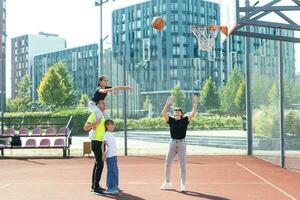 sommar högtider, sport och människor begrepp Lycklig familj med boll spelar på basketboll lekplats foto
