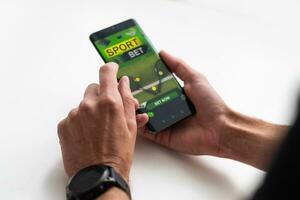 affärsman använder sig av smartphone mot hasardspel app skärm foto