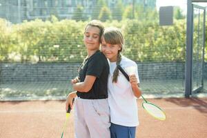 två flickor med badminton racketar på de fotboll fält. foto