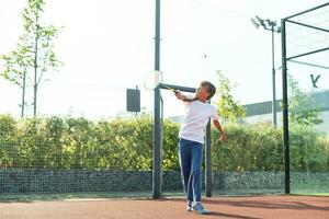 trevlig flicka med racket i händer spelar spel av tennis foto