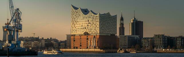 panorama av de hamn stad Inklusive de elbphilharmonic hall på solnedgång foto