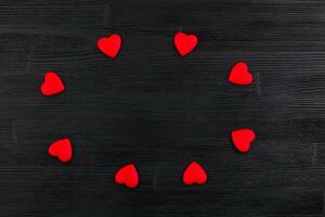 red hjärtan på svart trä- bakgrund foto