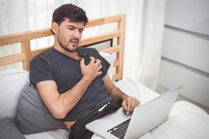affärsman som använder bärbar dator över natten orsakar hjärtinfarkt fel symptom. hälso- och sjukvård för överarbetade människors livsstilskoncept. tema för teknik och arbetsnarkoman