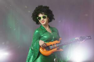 rolig pop- flicka med en leksak gitarr. kvinna i åttiotalet disko kostym. foto