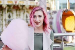 rosa hår flicka kort frisyr Framställ i nöje parkera på karusell bakgrund. foto