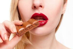 härlig leende Tonårs flicka äter choklad foto