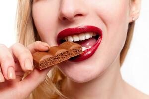 härlig leende Tonårs flicka äter choklad foto