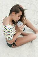 strand kvinna dricka kall dryck dryck har roligt på strand fest. foto