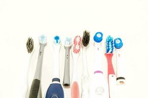 en grupp av annorlunda färgad tandborstar på en vit yta foto