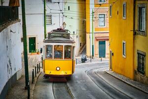 känd årgång gul spårvagn 28 i de smal gator av alfama distrikt i Lissabon, portugal foto