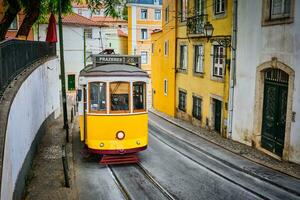 känd årgång gul spårvagn 28 i de smal gator av alfama distrikt i Lissabon, portugal foto