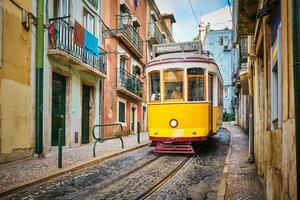 känd årgång gul spårvagn 28 i de smal gator av alfama distrikt i Lissabon, portugal foto