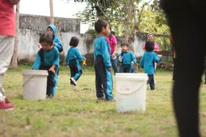 magelang,indonesia.12-05-2023.group av dagis skola barn och lärare spelar och inlärning utomhus. foto