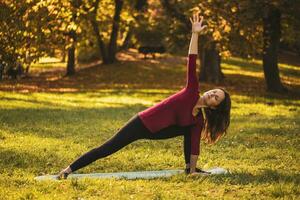 skön kvinna håller på med yoga i de natur, foto