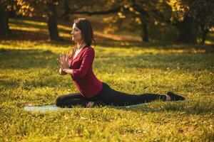 skön kvinna håller på med yoga i de natur, foto