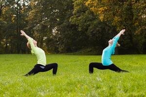 två kvinna håller på med yoga i natur. foto