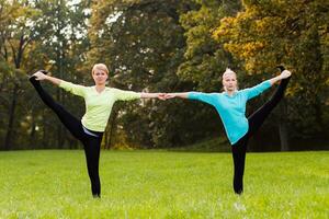 två kvinna håller på med yoga i natur. foto