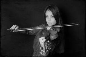 ung asiatisk kvinna spelar fiol foto