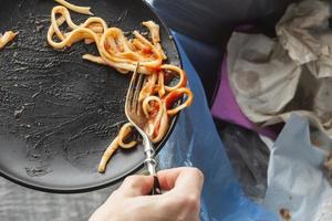 överbliven slösad spaghettipasta kastad i papperskorgen