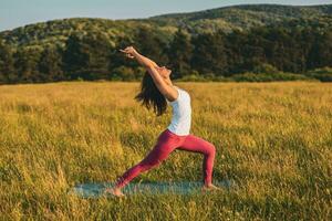 skön kvinna håller på med yoga i de natur foto