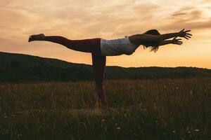 silhuett av en kvinna praktiserande yoga foto