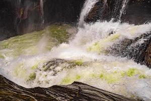 snabbt flödande flod vid rjukandefossen vattenfall, hemsedal, norge foto