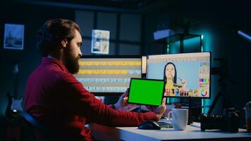 frilansare följande handledning på grön skärm läsplatta, inlärning på vilket sätt till bygga digital portfölj visa upp redigerad bilder. Foto redaktör tittar på guide på attrapp enhet handla om använder sig av retuschering programvara