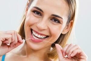 kvinna rengöring tänder med dental flock foto