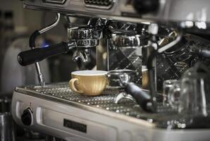 kaffemaskin med kaffekopp på café foto