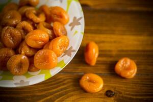 utsökt torkades aprikoser i en skål på en trä- tabell foto