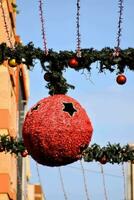 en röd boll hängande från en sträng med jul dekorationer foto