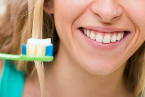 kvinna med skön friska vit tänder använder sig av tandborste foto