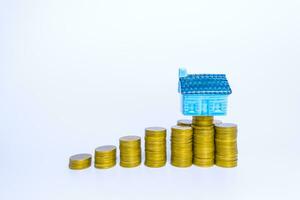 företag finansiera och pengar begrepp, pengar mynt stack växande Graf med hus modell investeringar, lån och verklig egendom begrepp foto