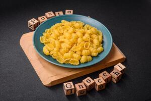 rå durum vete Gnocchi pasta med salt och kryddor i en keramisk tallrik foto