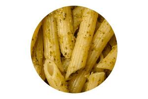 utsökt färsk pasta penne med grön pesto sås med basilika, salt och kryddor foto