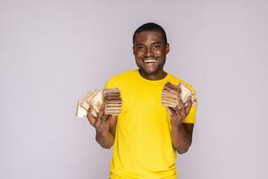 upphetsad och Lycklig ung svart man innehav en massa av pengar i både händer foto