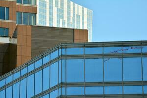 glas byggnad med transparent Fasad av de byggnad och blå himmel. strukturell glas vägg reflekterande blå himmel. abstrakt modern arkitektur fragment. samtida arkitektonisk bakgrund. foto