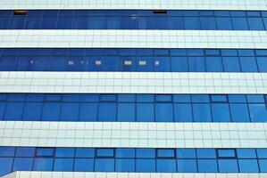 glas byggnad med transparent Fasad av de byggnad och blå himmel. strukturell glas vägg reflekterande blå himmel. abstrakt modern arkitektur fragment. samtida arkitektonisk bakgrund. foto