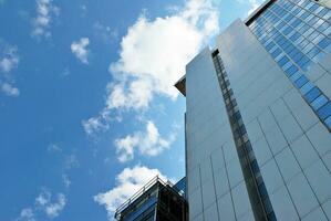 glas byggnad med transparent Fasad av de byggnad och blå himmel. strukturell glas vägg reflekterande blå himmel. abstrakt modern arkitektur fragment. samtida arkitektonisk bakgrund. foto