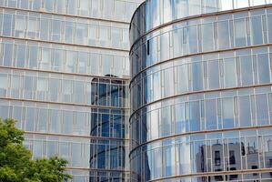 glas byggnad med transparent Fasad av de byggnad och blå himmel. strukturell glas vägg reflekterande blå himmel. abstrakt modern arkitektur fragment. samtida arkitektonisk bakgrund. foto