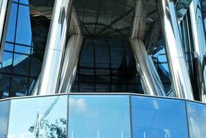 glas byggnad med transparent Fasad av de byggnad och blå himmel. strukturell glas vägg reflekterande blå himmel. abstrakt modern arkitektur fragment. samtida arkitektonisk bakgrund. foto