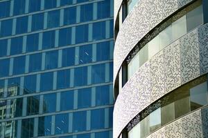 glas byggnad med transparent Fasad av de byggnad och blå himmel. strukturell glas vägg reflekterande blå himmel. abstrakt modern arkitektur fragment. samtida arkitektonisk bakgrund. foto