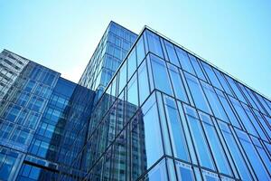 glas byggnad med transparent Fasad av de byggnad och blå himmel. strukturell glas vägg reflekterande blå himmel. abstrakt modern arkitektur fragment. samtida arkitektonisk bakgrund. foto