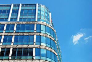 glas byggnad med transparent Fasad av de byggnad och blå himmel. strukturell glas vägg reflekterande blå himmel. foto