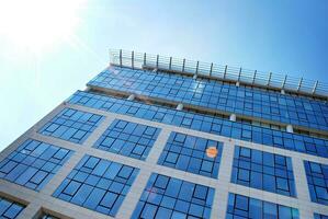 glas byggnad med transparent Fasad av de byggnad och blå himmel. strukturell glas vägg reflekterande blå himmel. abstrakt modern arkitektur fragment. samtida arkitektonisk bakgrund. foto